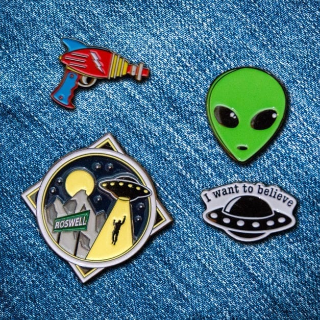 "I Want To Believe" Aliens theme four piece enamel pin set on denim fabric.