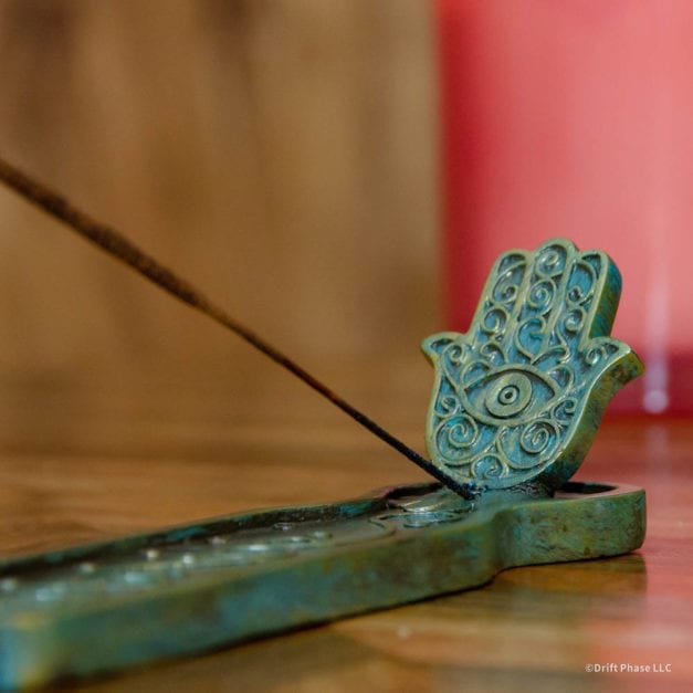 Green and bronze hamsa hand incense burner with burring incent - Close-Up