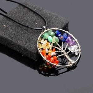 Close-Up Photo of the 7 Chakra Tree of Life Natural Stone Pendant against a black background.