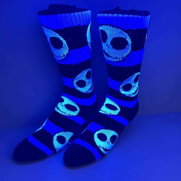 Nightmare Before X-Mas Jack Skellington Crew Socks glowing under black light.